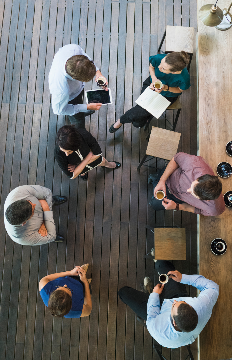 Overhead view of employees talking and drinking cofee. 